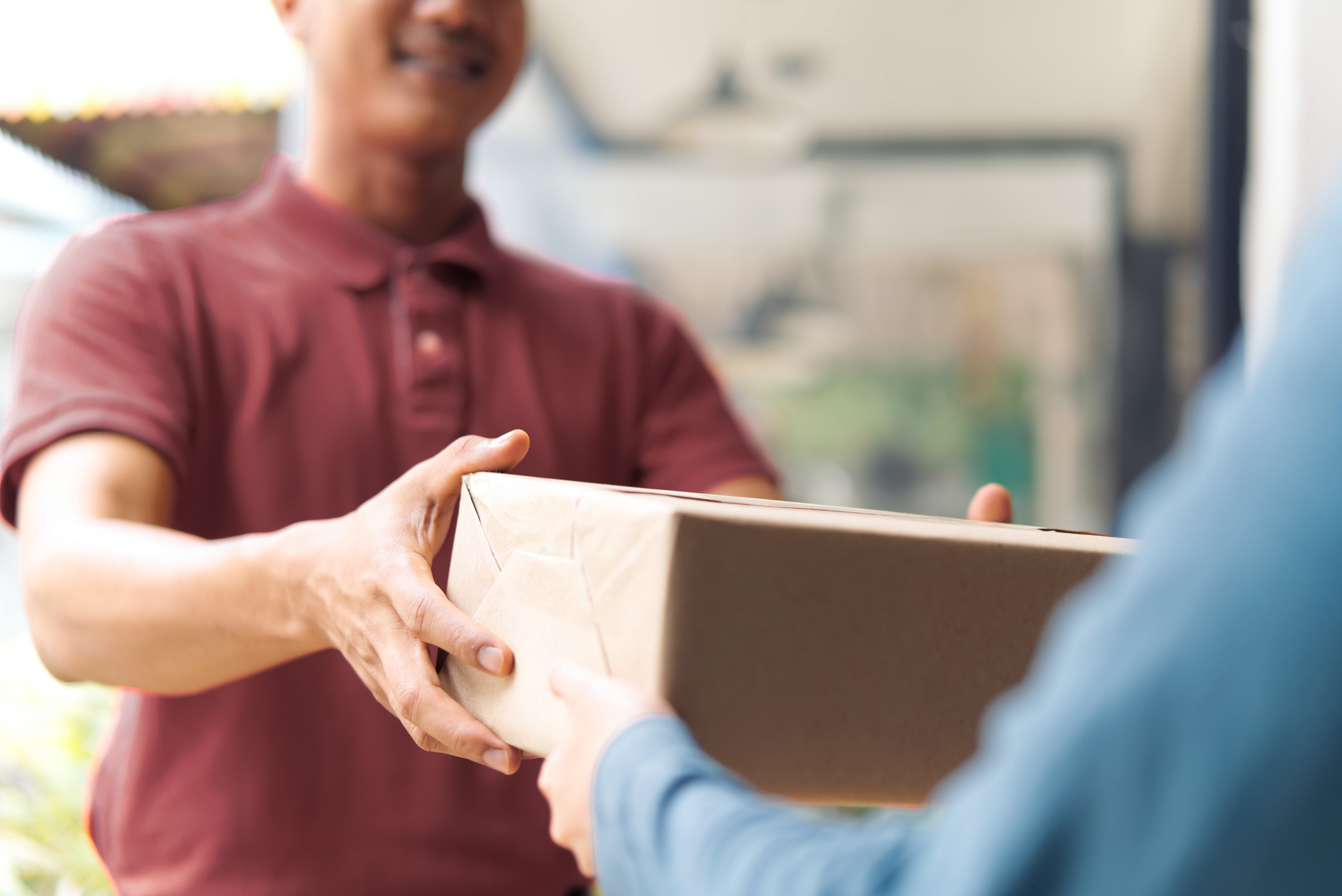 Mitarbeiter übergibt ein Paket an einen Kunden